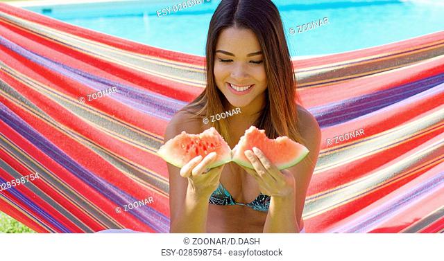 Smiling young woman holding one watermelon slice
