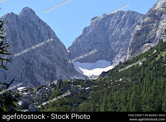 PRODUCTION - 12 August 2023, Bavaria, Ramsau: Remnants of snow lie on the Blaueis glacier. Researchers give them only a few more years: The last glaciers on...