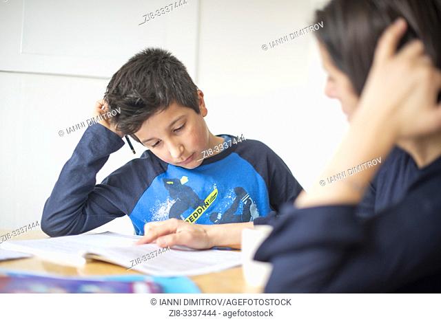 Private tutoring at home-10-11 years boy having a maths lesson at home-selective focus