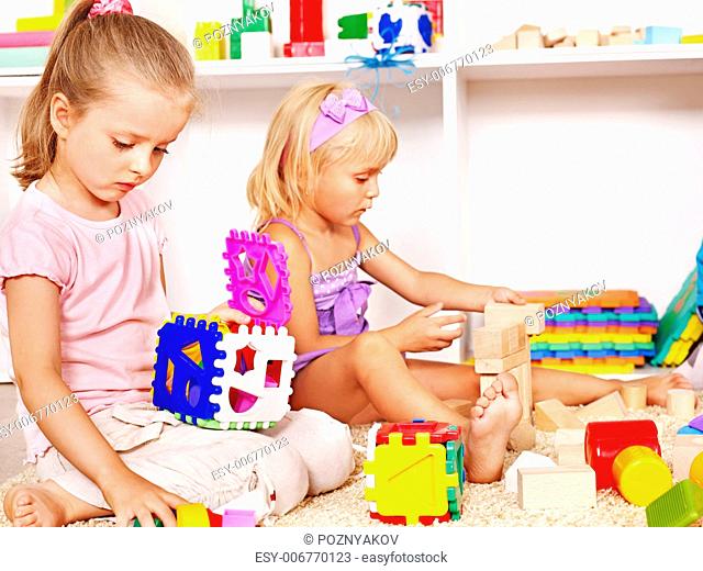 Children in kindergarten stacking block