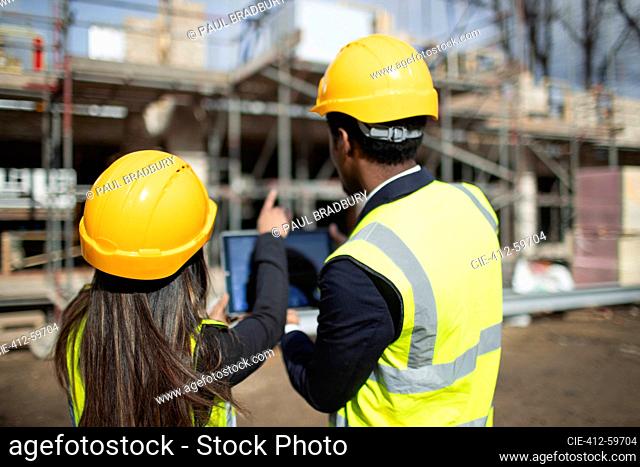 Engineer and architect with digital tablet at sunny construction site