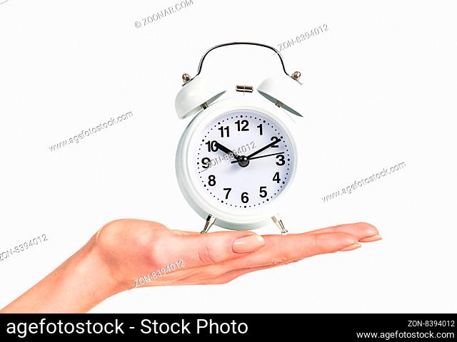 Alarm clock stands on the human palm isolated on white background