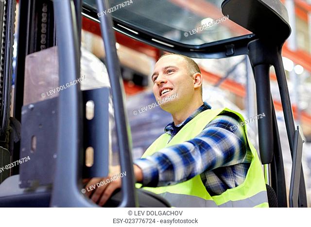 wholesale, logistic, loading, shipment and people concept - man or loader operating forklift loader at warehouse