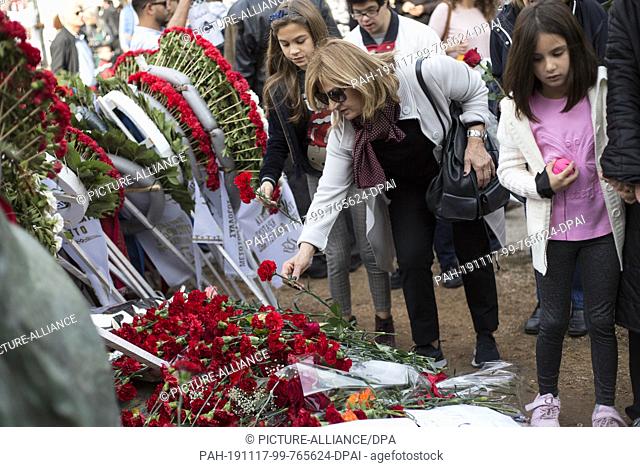 17 November 2019, Greece, Athen: A woman lays a red carnation at the monument to the victims of the student uprising on the 46th anniversary of the bloody...