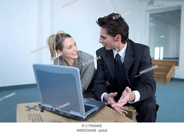 Businessman and businesswoman talking in empty hall