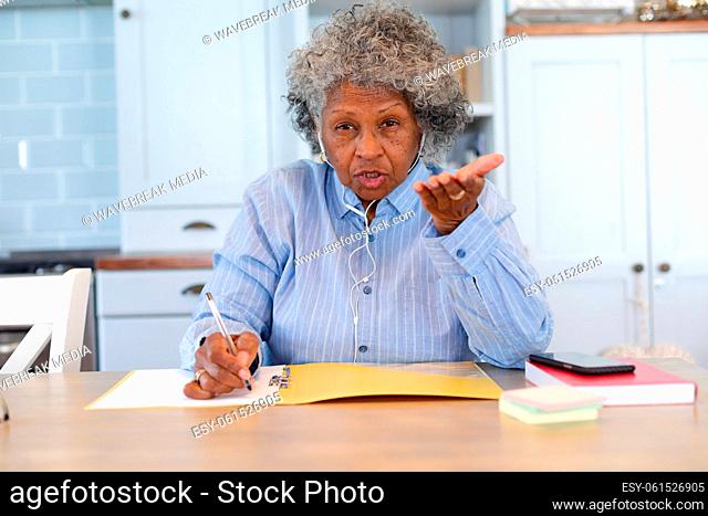 Portrait of african american senior female doctor talking looking at the camera at home