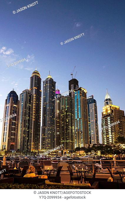 Night cityscape and outdoor restaurant on the promenade that meanders around Dubai Marina, Dubai, UAE