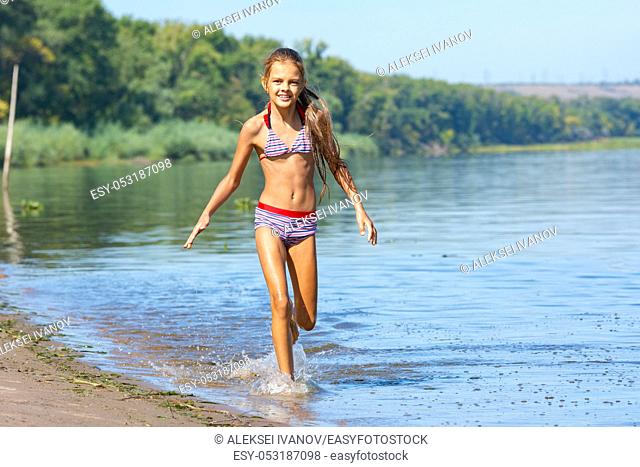 Ten year old girl runs along the river
