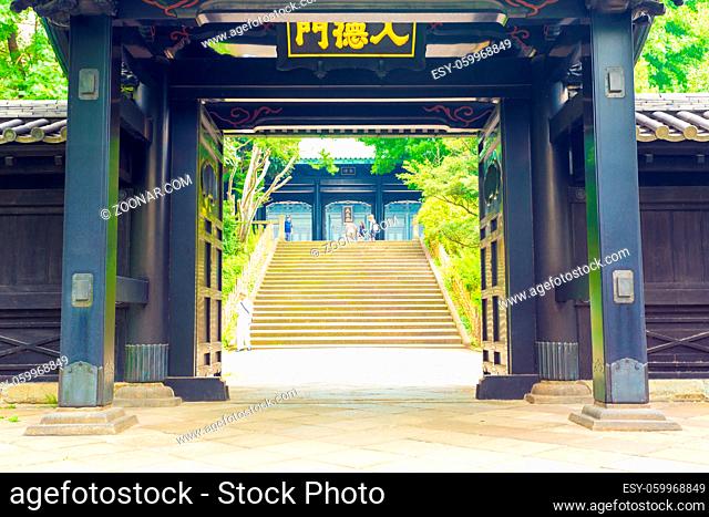Stairs seen through open entrance doorway to historic Yushima Seido, a Confucian temple in Tokyo, Japan. Horizontal