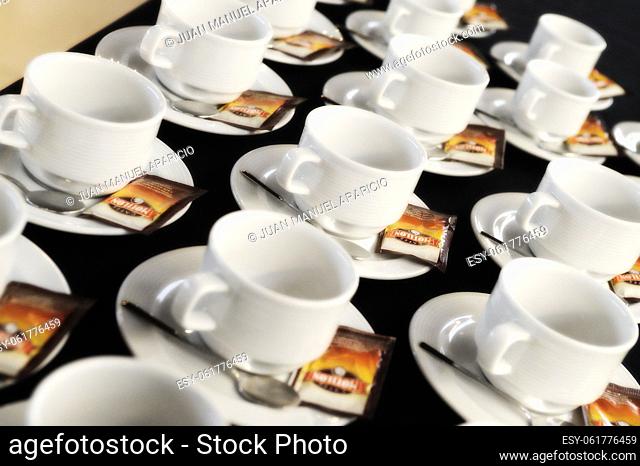 Cups, spoons and sugar sachets ready to serve coffee