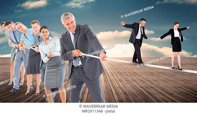 Business people walking on rope while colleagues pulling it on boardwalk