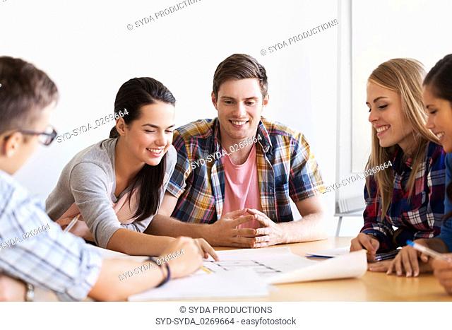 group of smiling students with blueprint