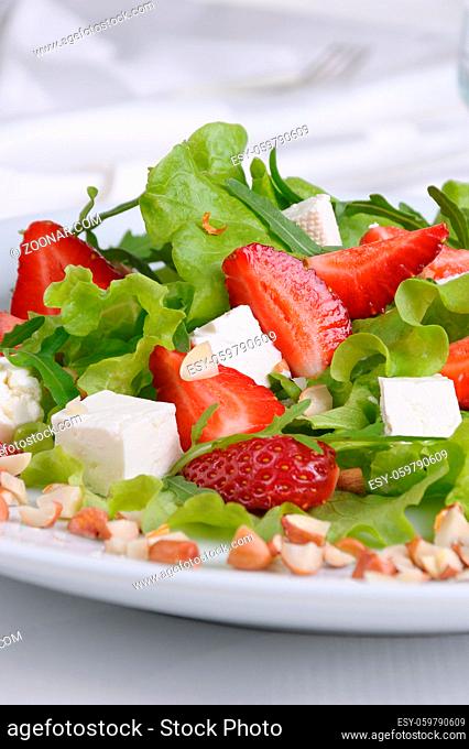 Salad of lettuce, arugula, strawberries, feta cheese and peanuts