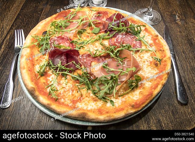 A pizza with parma ham and ruccola