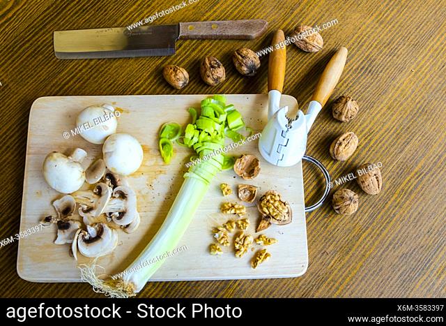 Table with vegetarian diet products including walnuts, mushrooms and leek