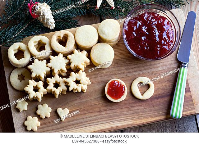 Preparation of traditional Linzer Christmas cookies - filling the cookies with strawberry jam