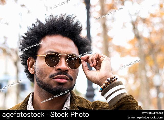 Close-up of handsome man with afro hair wearing sunglasses