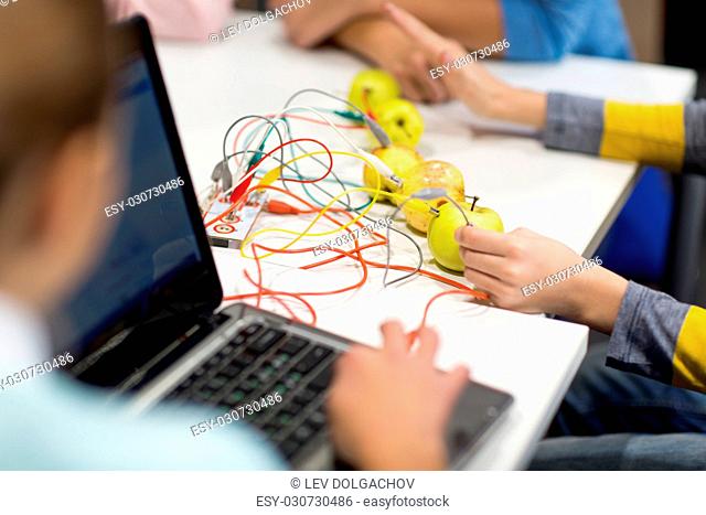 education, technology, science, programming and people concept - kids with invention kit and laptop at robotics school