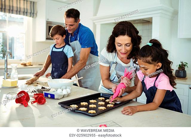Happy family preparing cookies in kitchen