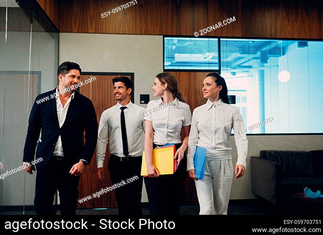 Businessman and businesswoman team in face masks walking along the wall to office meeting. Business people group conference discussion concept