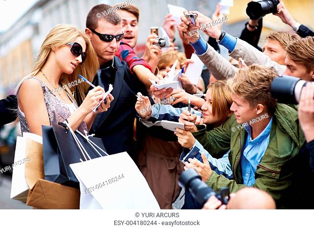 Beautiful celebrity signing an autograph for one of her fans