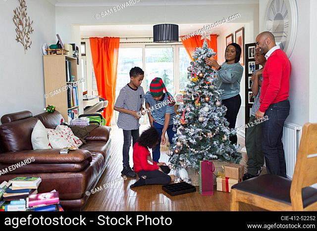 Family decorating Christmas tree in living room