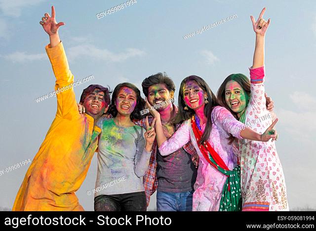 YOUNG MEN AND WOMEN POSING TOGETHER WHILE CELEBRATING HOLI