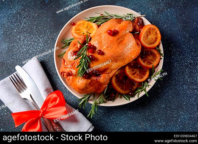 Roasted/baked whole chicken with spices, orange and herbs. Christmas food concept