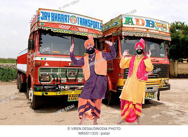 Dancers performing folk dance bhangra in front of lorries MR779B, 779C