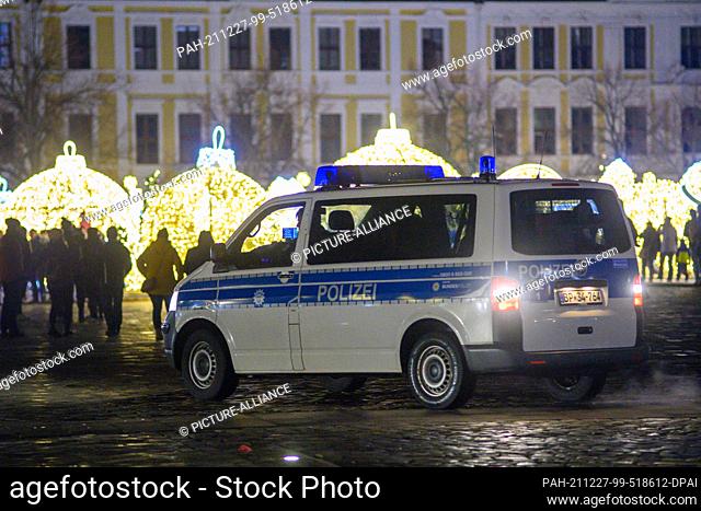 27 December 2021, Saxony-Anhalt, Magdeburg: A police vehicle stands on the Domplatz. There, a demonstration procession gathered