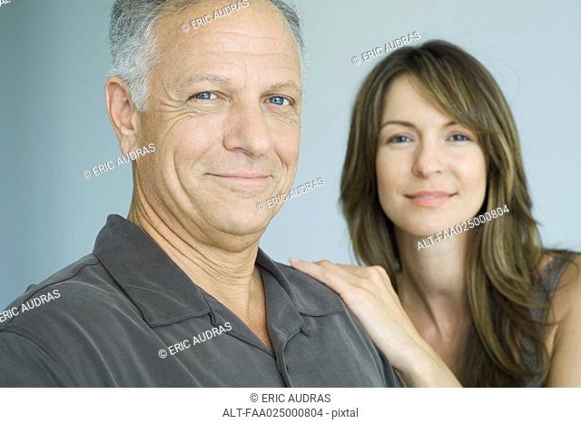 Mature father and adult daughter smiling at camera, portrait