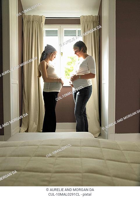 Pregnant friends in bedroom