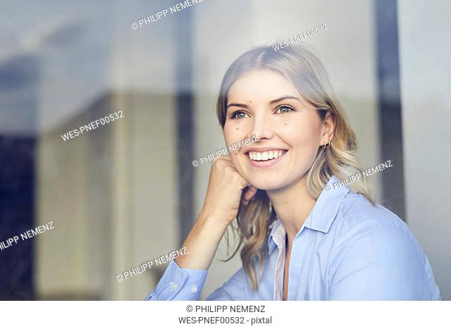 Portrait of content businesswoman looking out of window