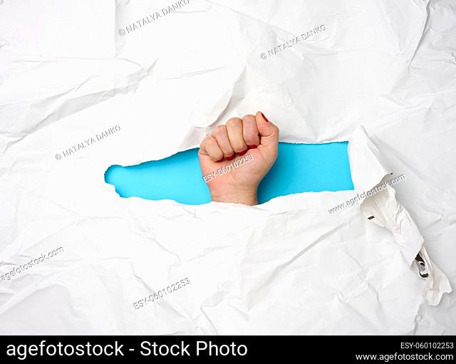 female fist sticking out of torn hole on white paper, freedom