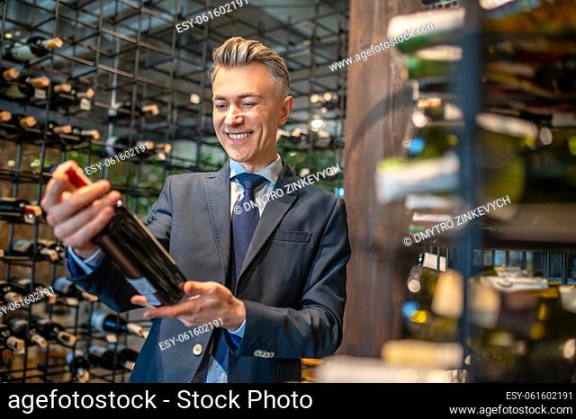 Wine store. A male client choosing wina in a wine store