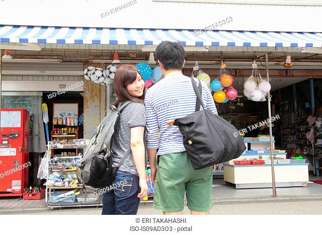 Young couple standing at shop front