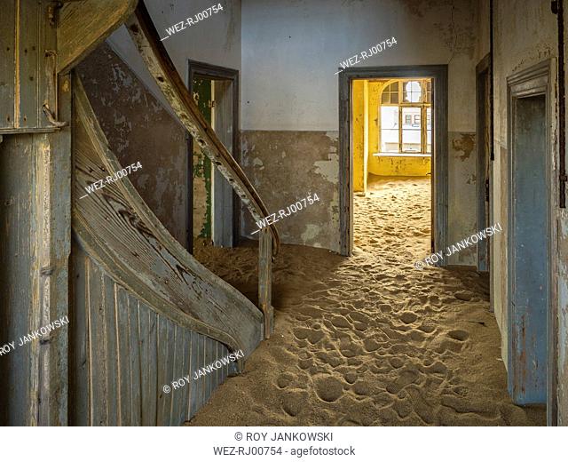 Africa, Namibia, inside a house of ghost town Kolmanskop, wooden door and sand