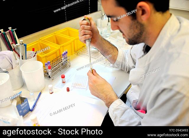 FRANCE - PARIS - LABORATORY A laboratory technician handles a variable volume micropipette and prepares samples for viral analysis in a tube concentrator