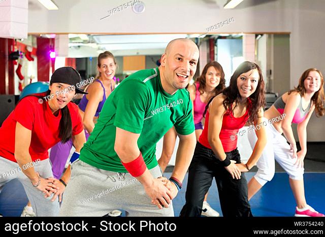 Fitness - Young people doing Zumba training or dance workout in a gym