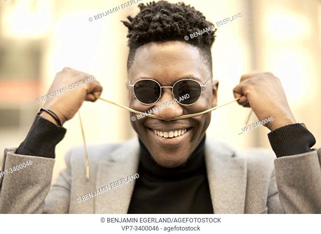 Young African man with chain in hands, in Munich, Germany