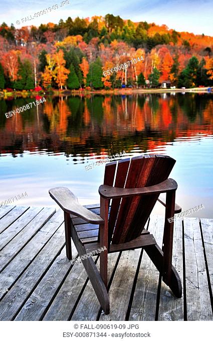 Wooden dock with chair on calm fall lake