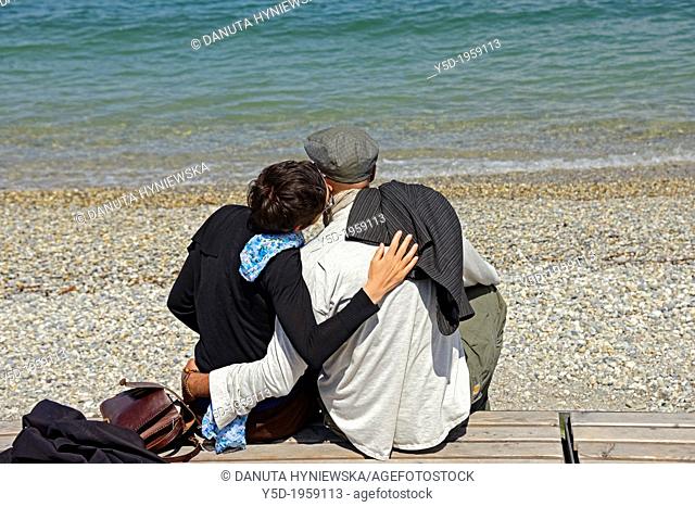 embracing, kissing couple at the beach, Lake Geneva shore, Paquis plage, Paquis beach, Lac Leman, Geneva, Switzerland