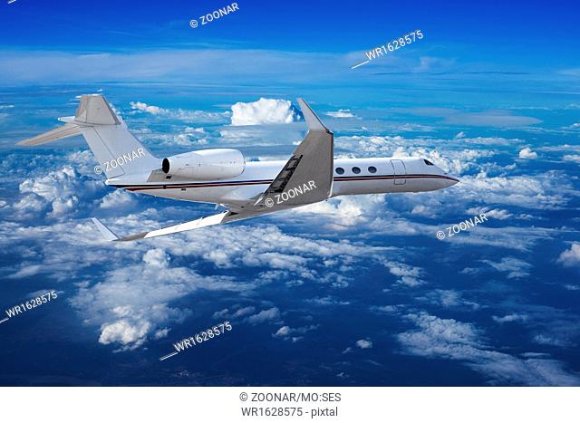 Private jet cruising above the clouds