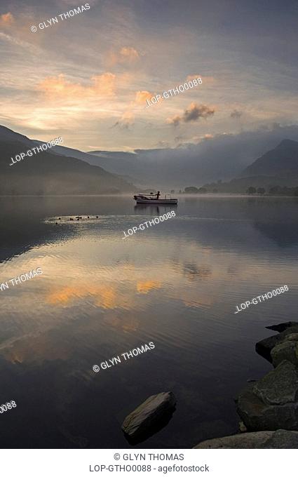 Wales, Gwynedd, Llanberis, Sunrise over the reflective calm waters of Lake Padarn in Llanberis