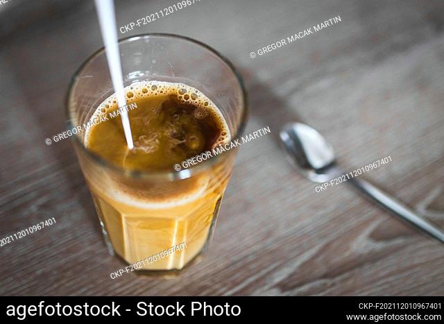 Milk pouring into instant coffee in a glass with spoon, in Prague, Czech Republic, November 9, 2021. (CTK Photo/Martin Macak Gregor)