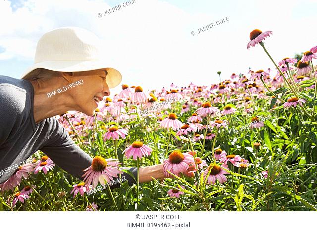 Smiling Caucasian woman looking at flowers