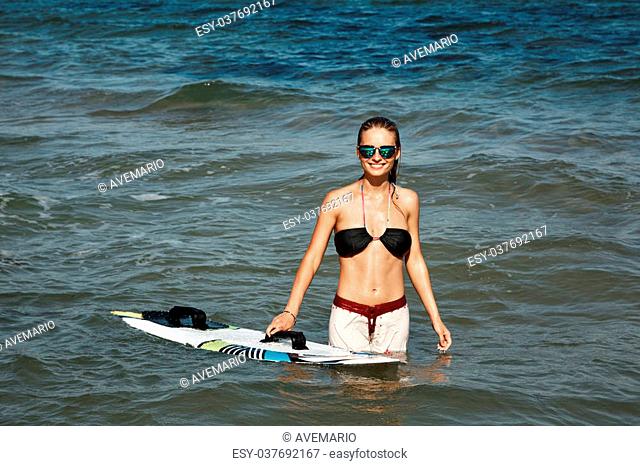 Portrait of beautiful blond active woman spending summer holidays on the beach, enjoying kite board