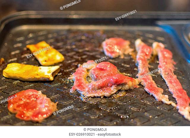 Grilled raw meat (barbeque, bbq) cooking on wagyu grill in BBQ. yakiniku grill buffet restaurant