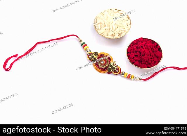 Indian festival: Raksha Bandhan background with an elegant Rakhi on a white background. A traditional Indian wrist band which is a symbol of love between...