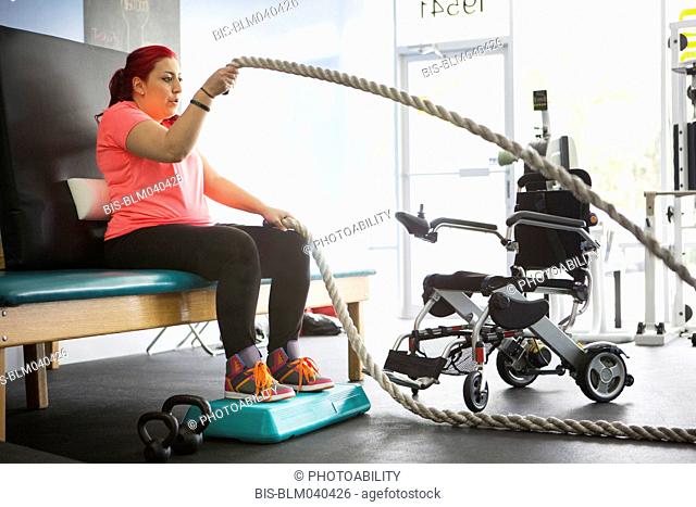 Mujer discapacitada haciendo fisioterapia en el gimnasio